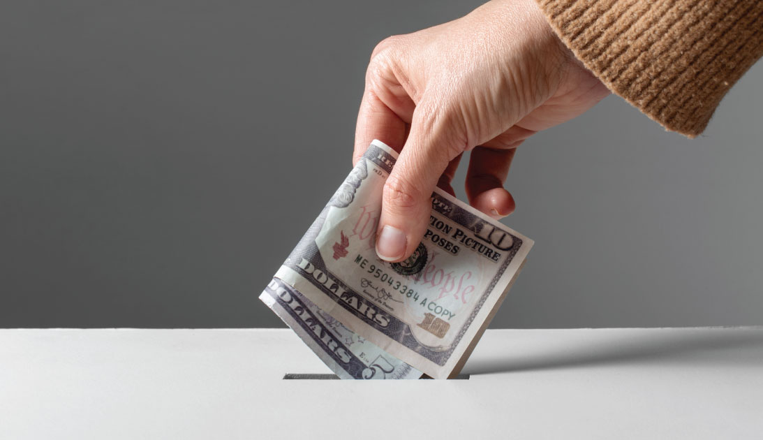 Person donating funds to a donation box