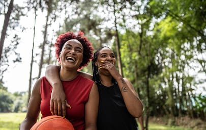 Two friends playing basketball and laughing