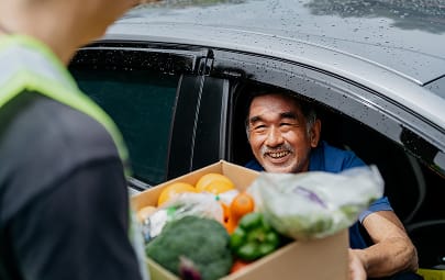 A man picking up groceries from a drive through pantry